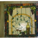 Arched Wine Bottle/ Grapes Design - This 4\' x 4\' Window was commissioned by a nice couple in Woodbury, Mn to set off the final touches of their private Winery and Lounge.  I included a bottle of their favorite wine, grapes and vinery, and wine glasses, and brought all together beneath an amber arch design.  It is accented with faceted jewels made in Germany which gives this masterpiece a three dimensional look.